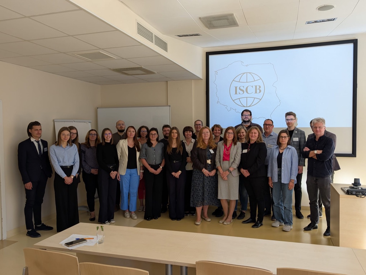 Wspólne zdjęcie uczestników konferencji w sali wykładowej SGH, na ekranie logo ISCB